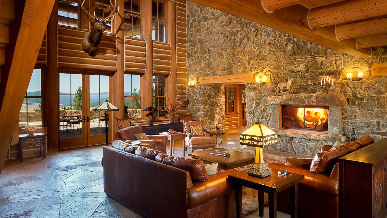 a living room with a stone fireplace and leather couches