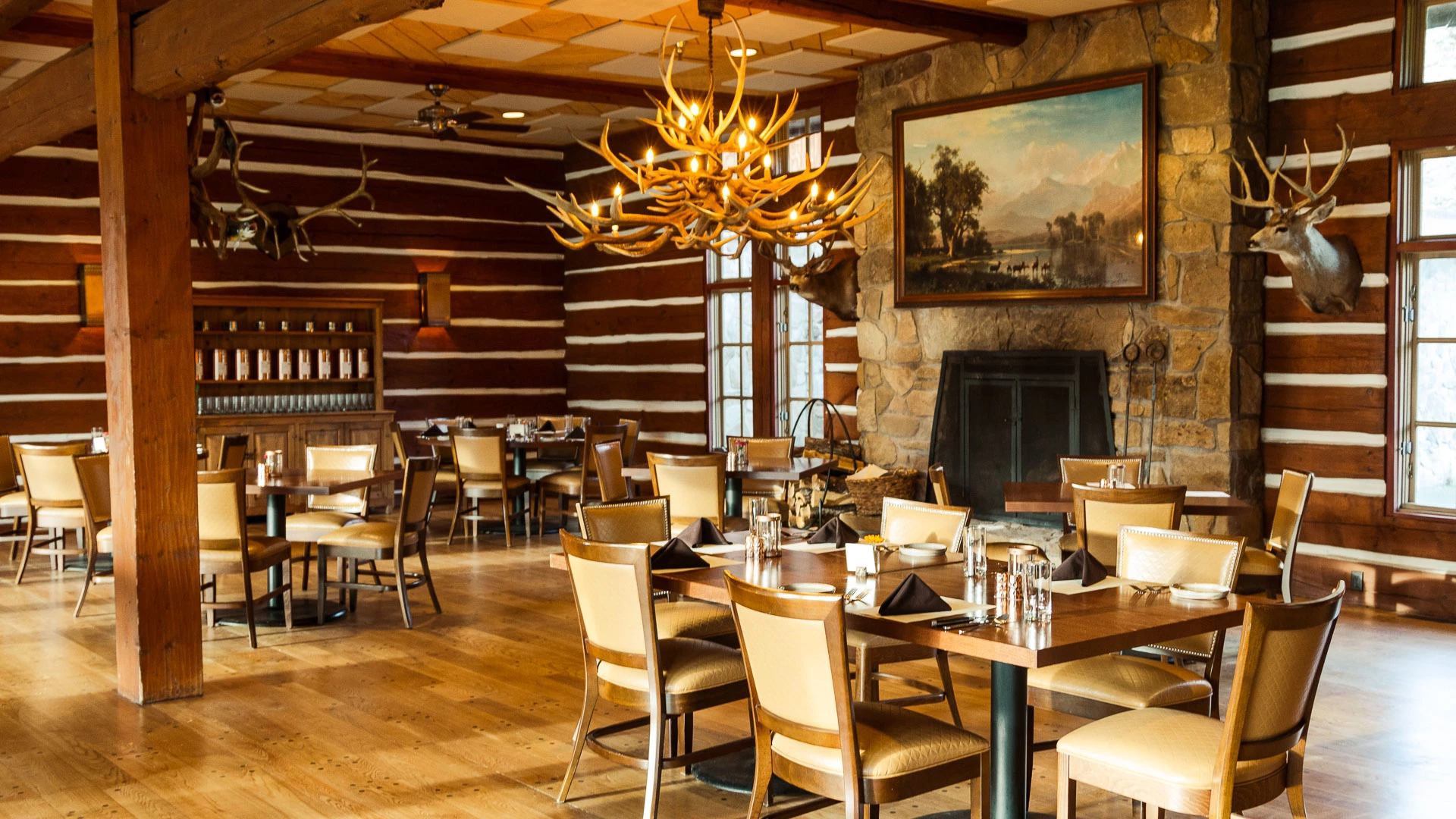 a room with a chandelier and tables and chairs