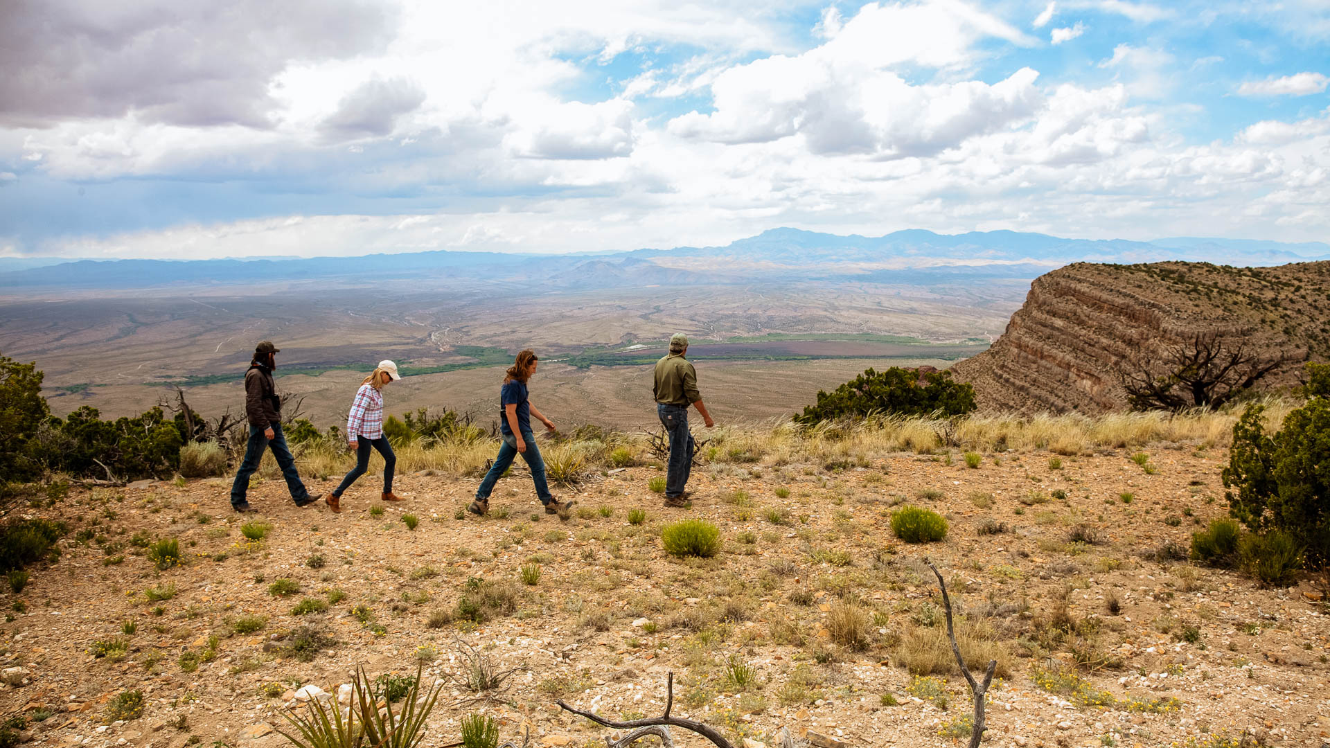 a group of people walking on a hill