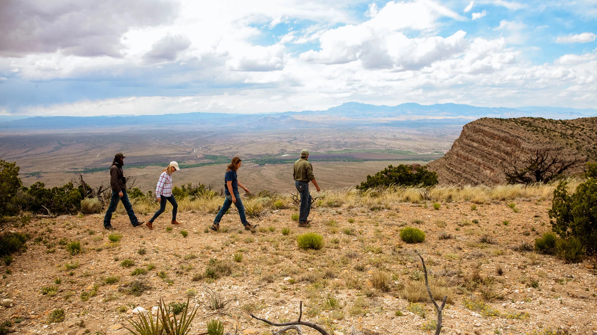 a group of people walking on a hill