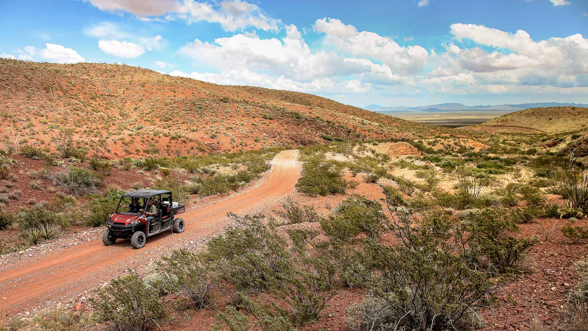 a vehicle driving on a dirt road