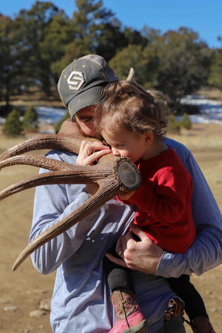 a man holding a child with antlers