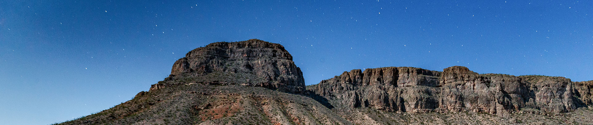 a rocky mountain with stars in the sky