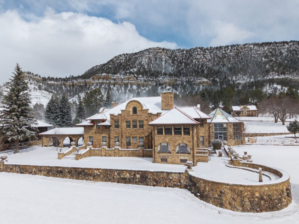 a large stone house with snow on the ground