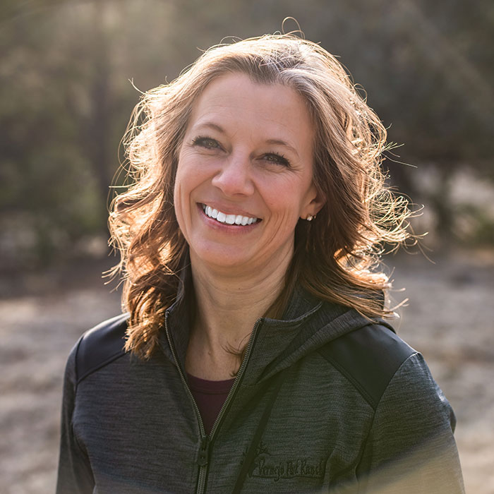 a woman smiling outside in the sun
