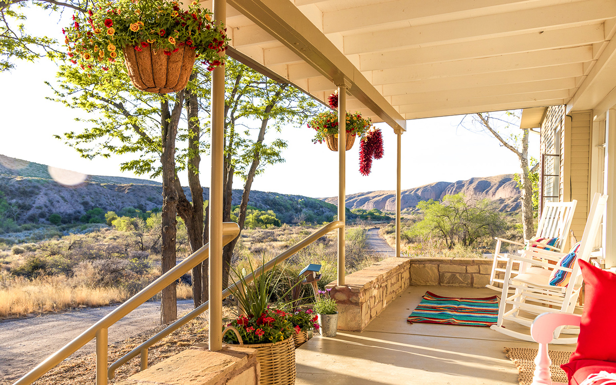 a porch with a blanket and plants on it