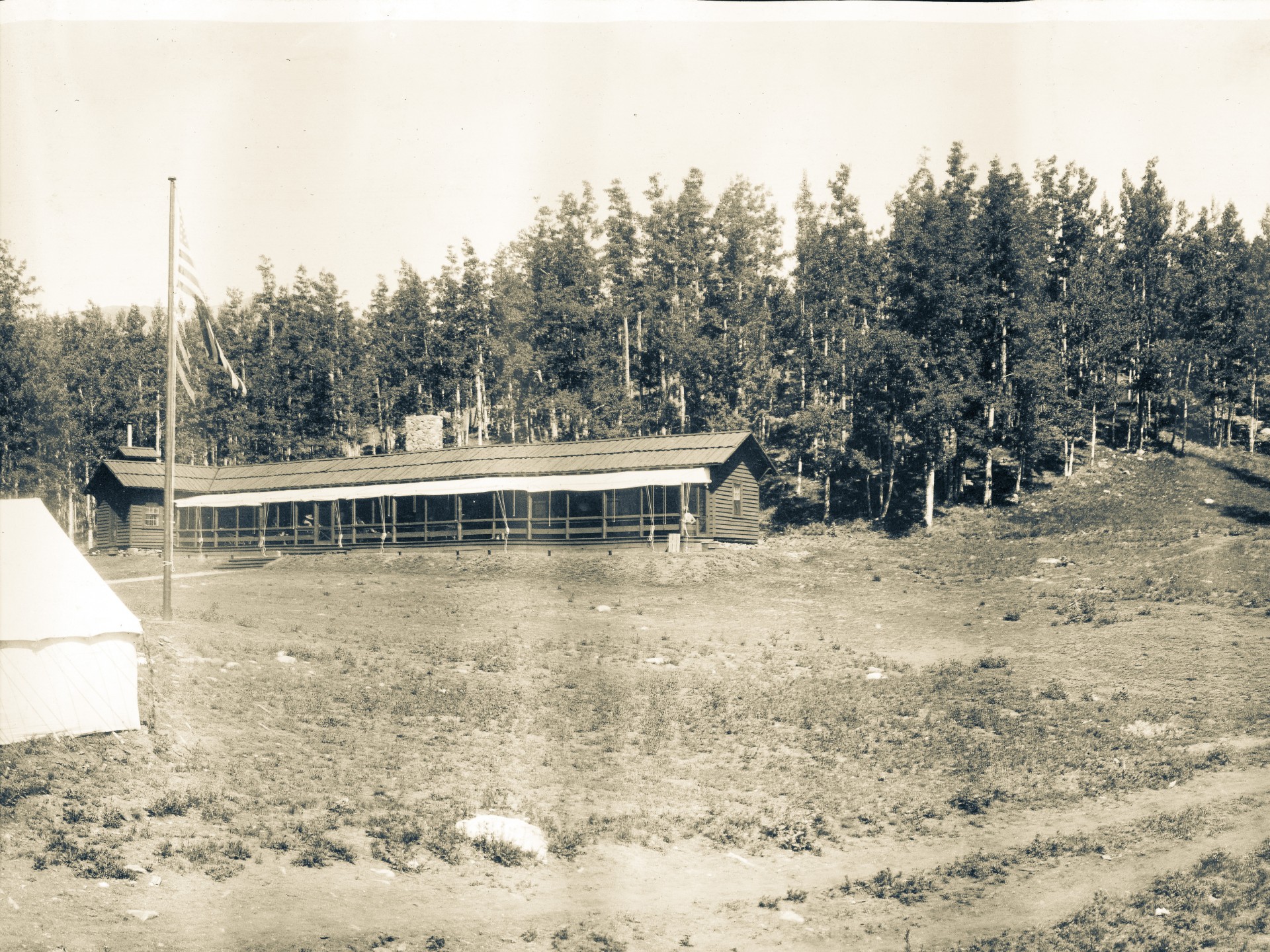a building in a field with trees in the background