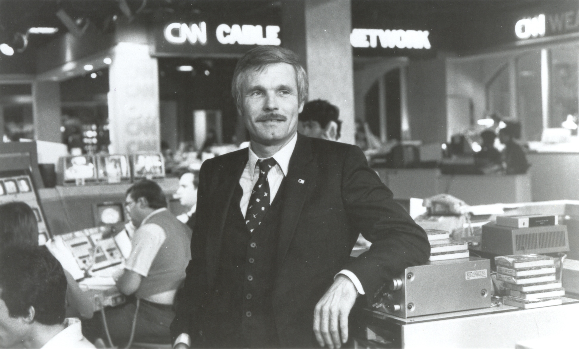 a man in a suit leaning on a machine
