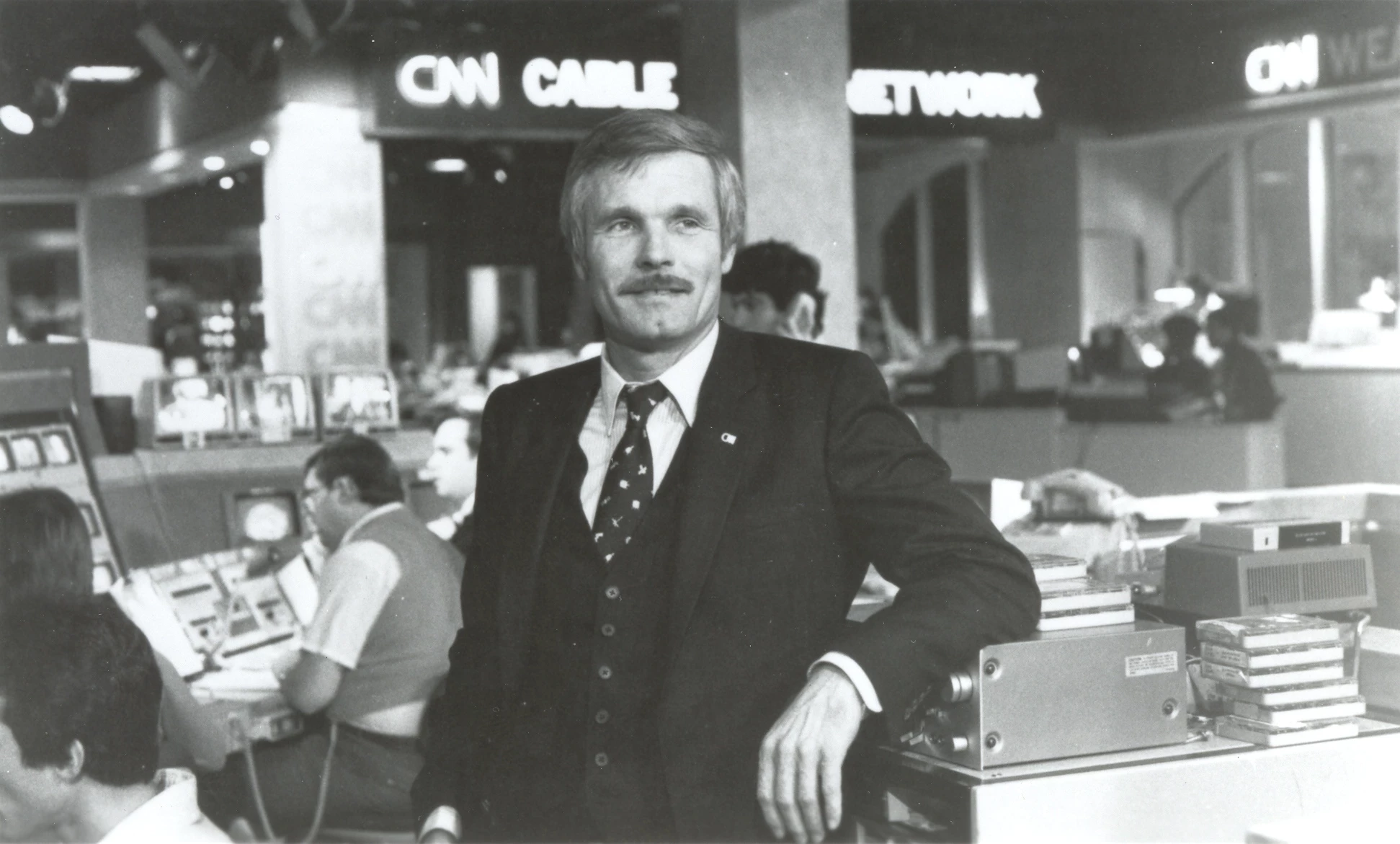 a man in a suit leaning on a machine