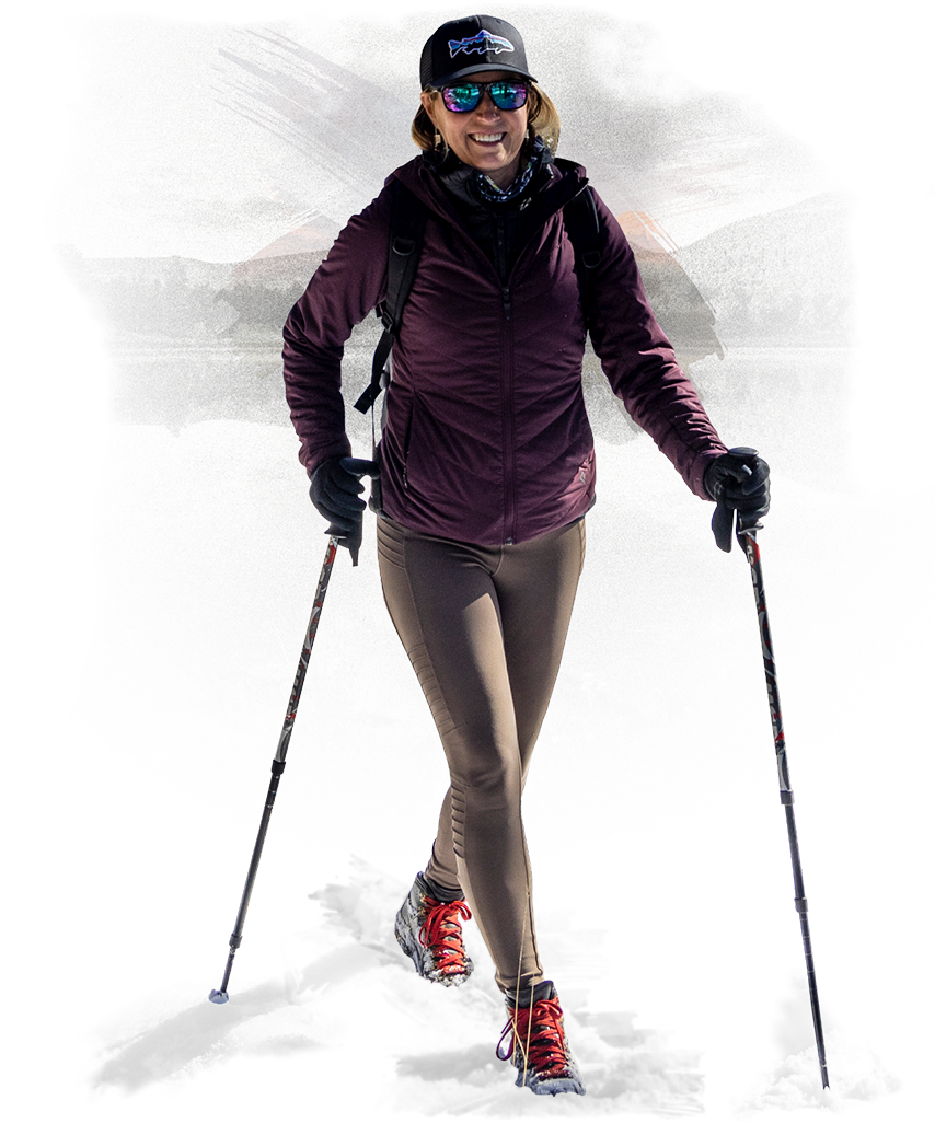 a woman wearing sunglasses and a backpack and walking with poles