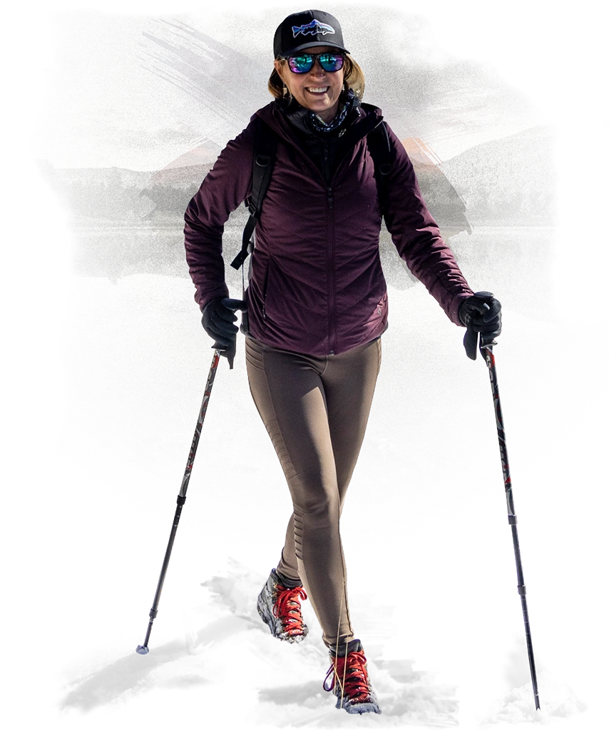 a woman wearing sunglasses and a backpack and walking with poles