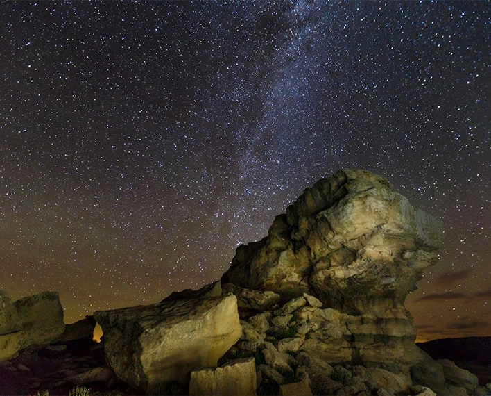 a rock formation with stars in the sky