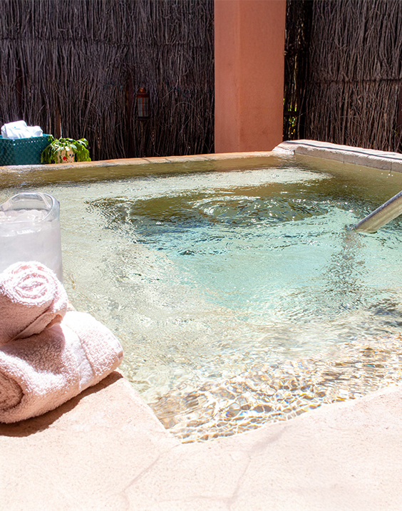 a hot tub with a towel and a bucket of ice