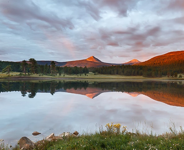 a lake with trees and mountains in the background