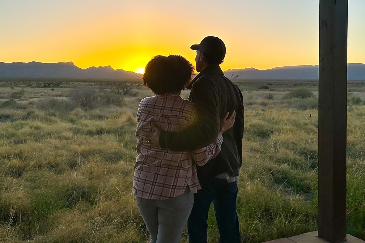 a man and woman hugging in a field