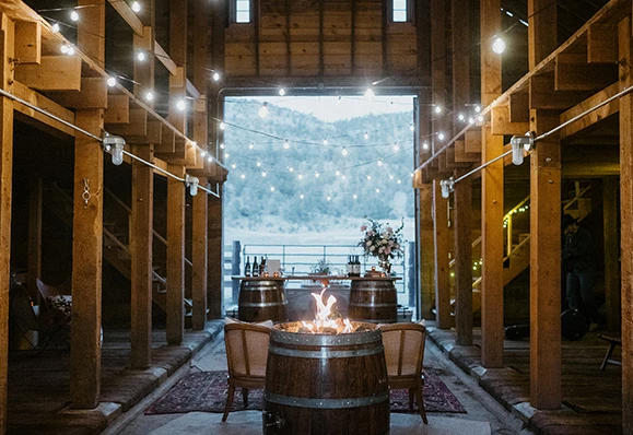a room with a fire pit and chairs