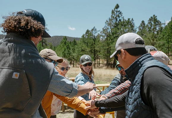 a group of people putting their hands together