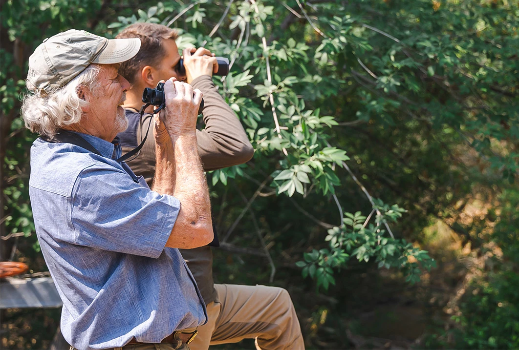 a man and a man looking through binoculars