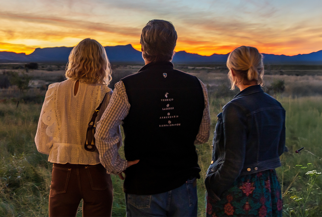 a group of people looking at a sunset