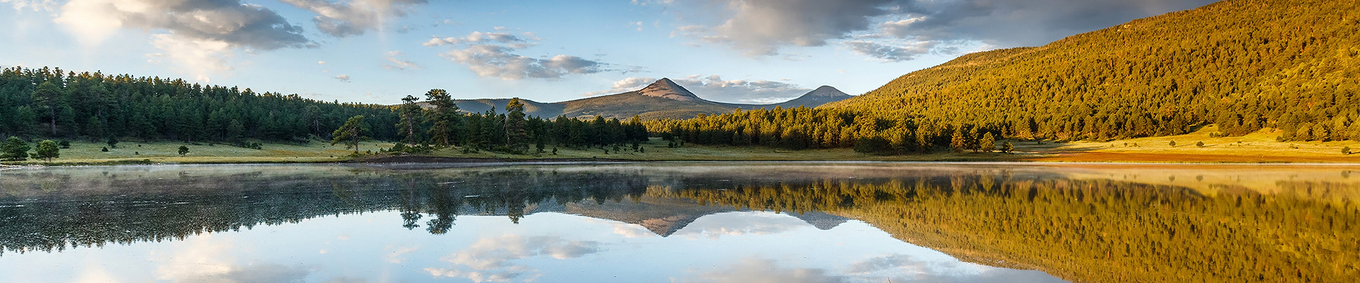 a lake with trees and mountains in the background