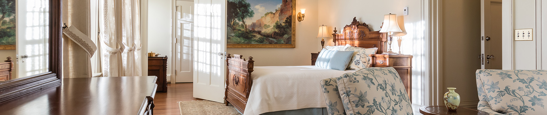 a bed in a room with a painting on the wall