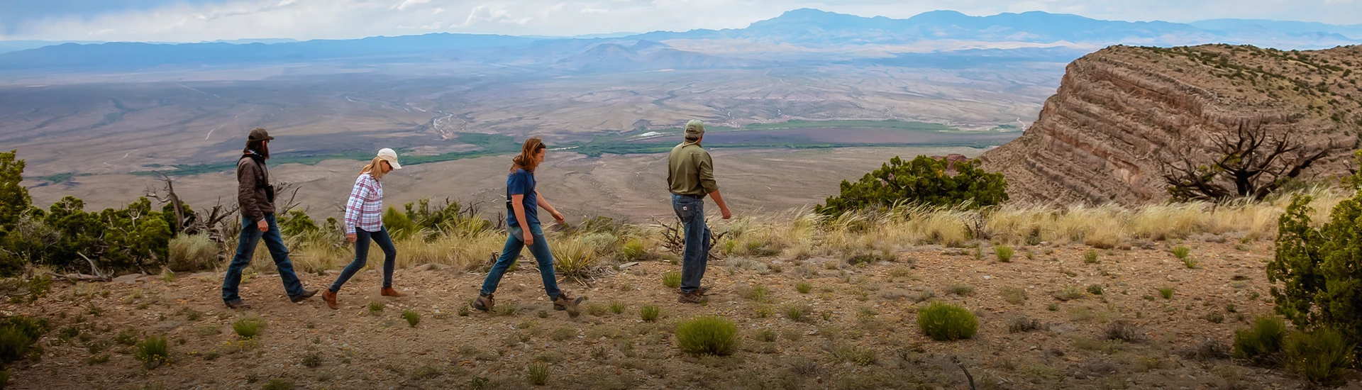 a man and woman walking on a hill