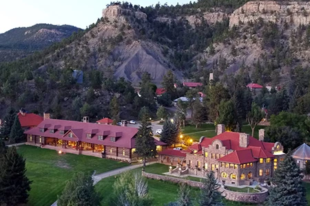 a large building with a red roof surrounded by trees