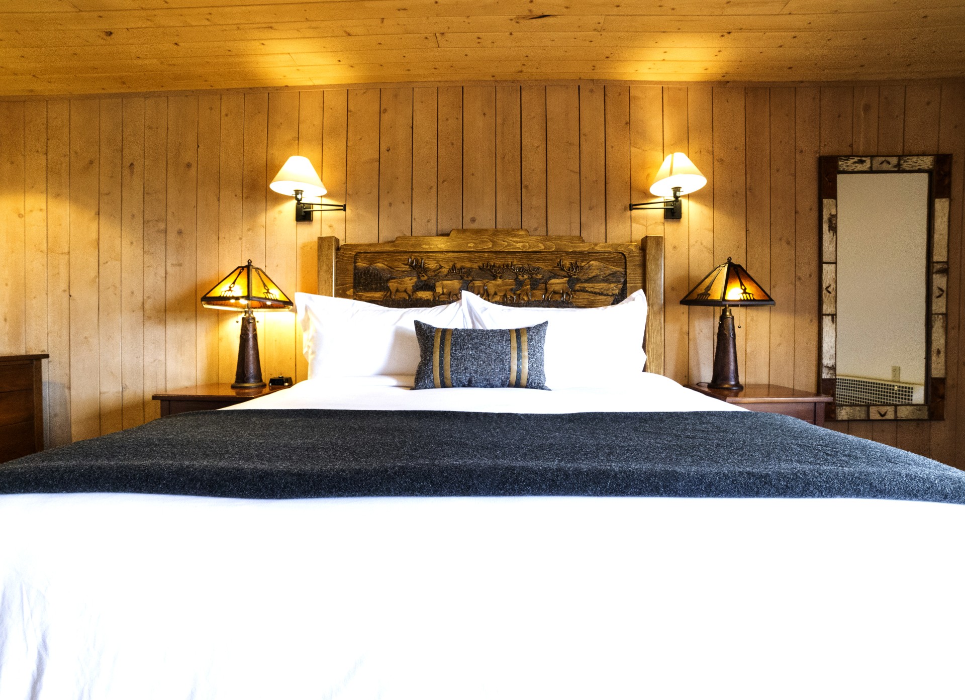 a bed with a wood headboard and lamps