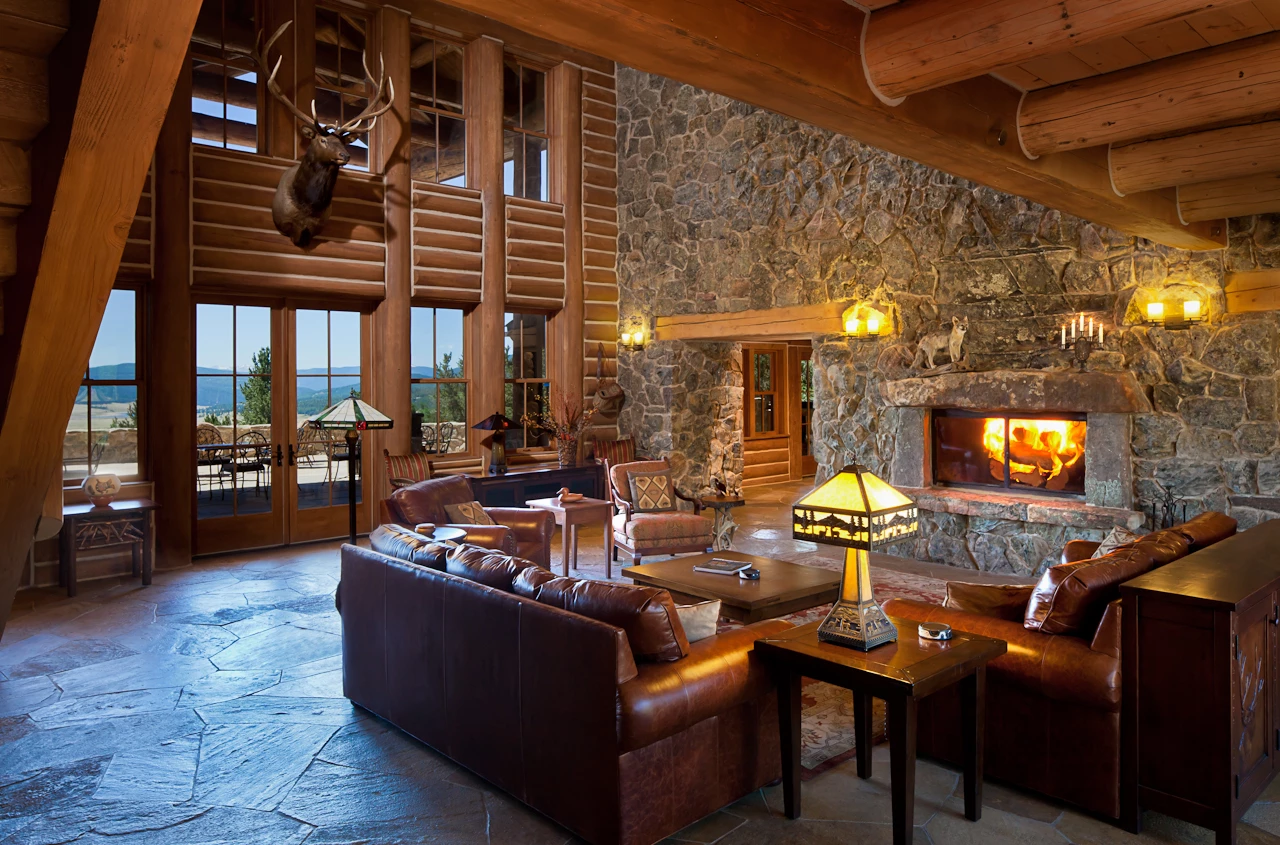 a living room with a stone fireplace and leather couches