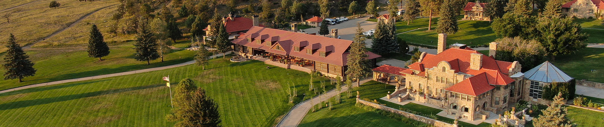 a building with a lawn and cars parked in the background