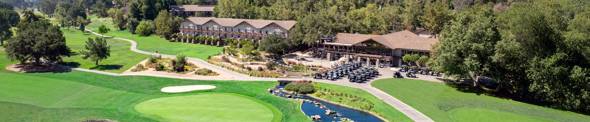 a golf course with a parking lot and a building
