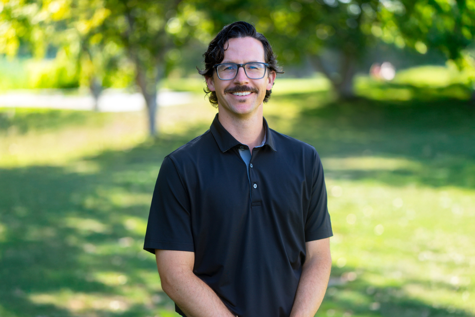 a man with mustache wearing glasses and a black shirt
