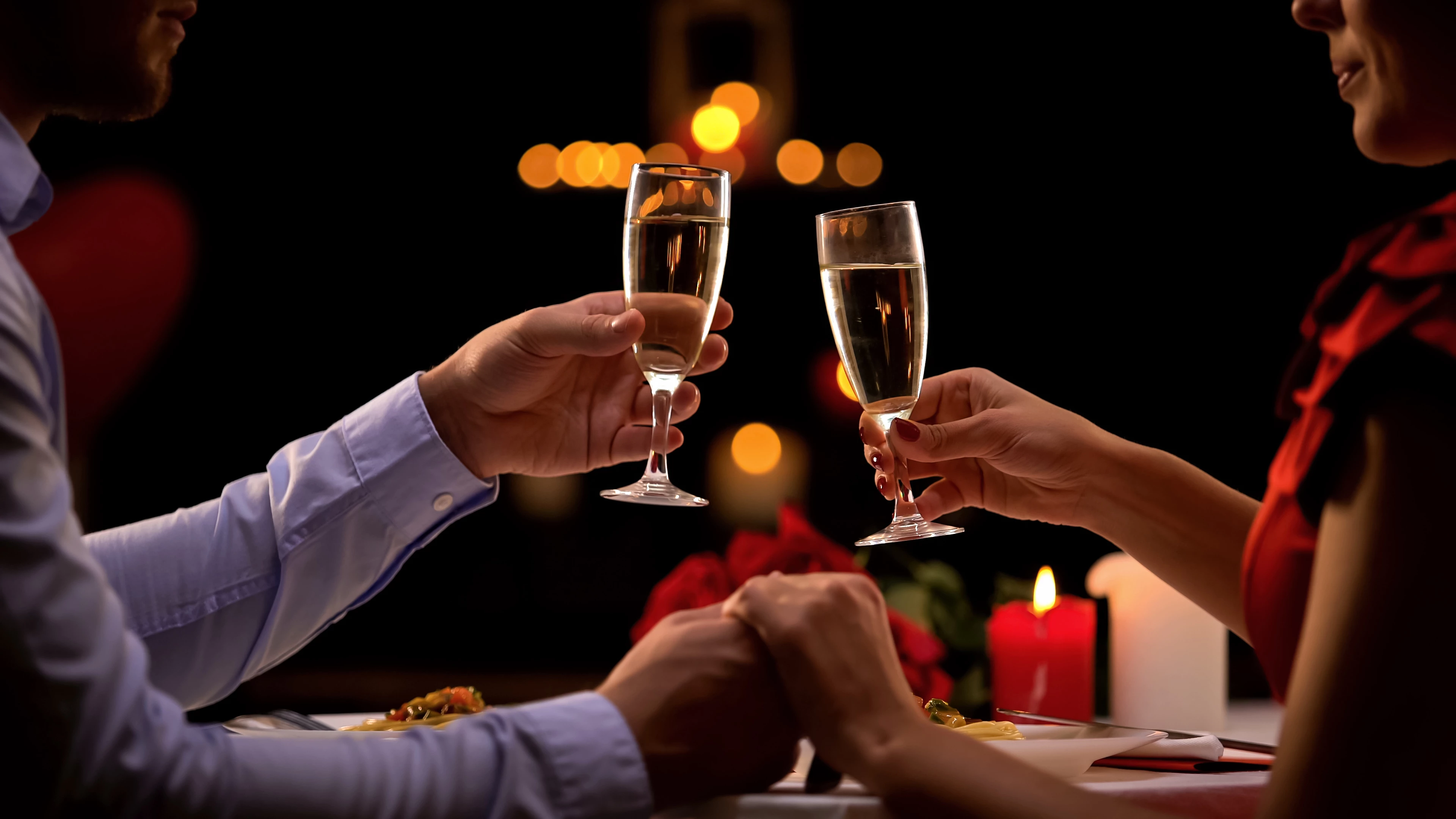 a couple holding hands with champagne glasses