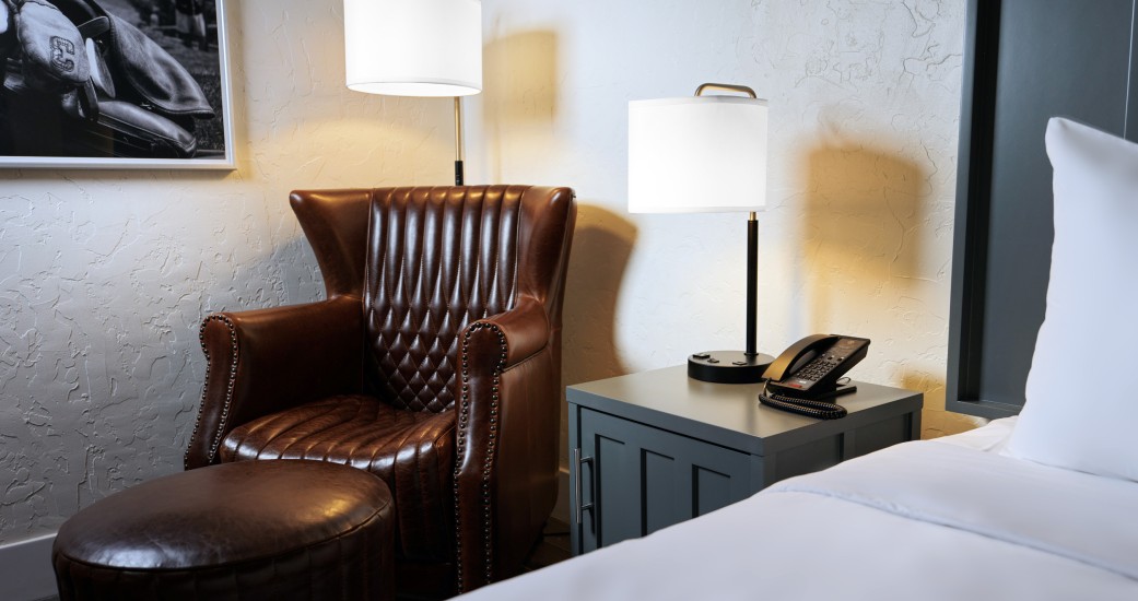 a chair and a telephone next to a bed