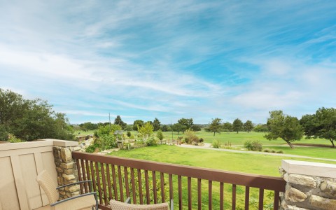 a deck with chairs and a table and a fence