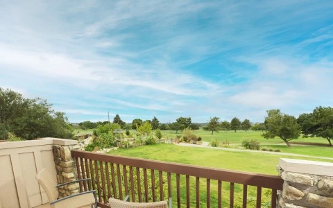a deck with chairs and a table and a fence