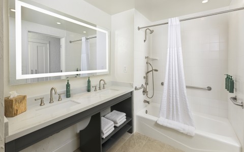a bathroom with a white shower and a white bathtub
