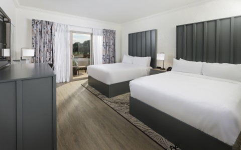 a room with two beds and a wood floor
