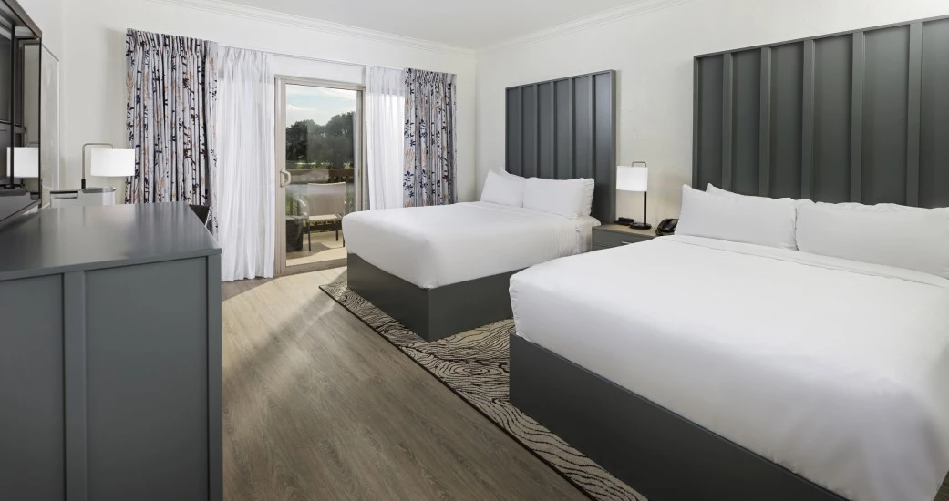 a room with two beds and a wood floor