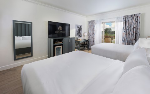 a room with two beds and a television