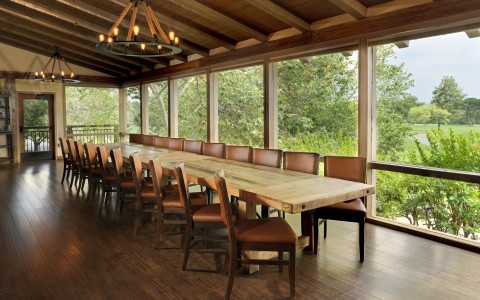 a long table with chairs in a room with windows