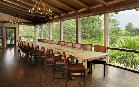 a long table with chairs in a room with windows