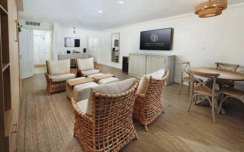 a room with wicker furniture and a television