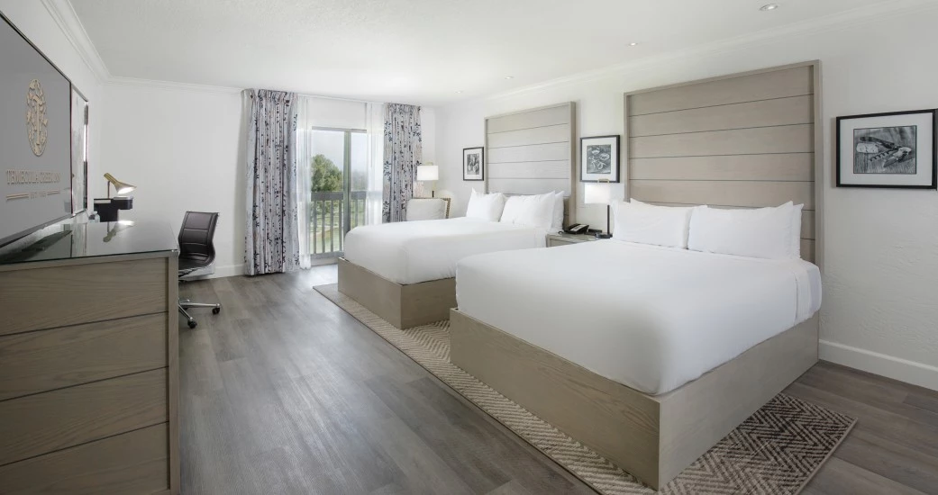 a room with two beds and a desk