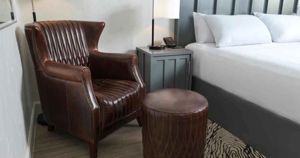 a chair and a bed in a hotel room