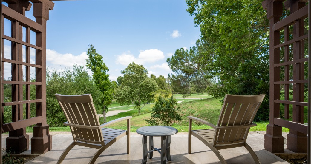 a wooden patio with chairs and a table
