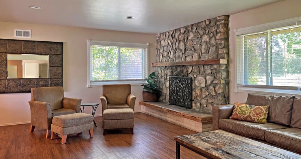 a living room with a fireplace and chairs