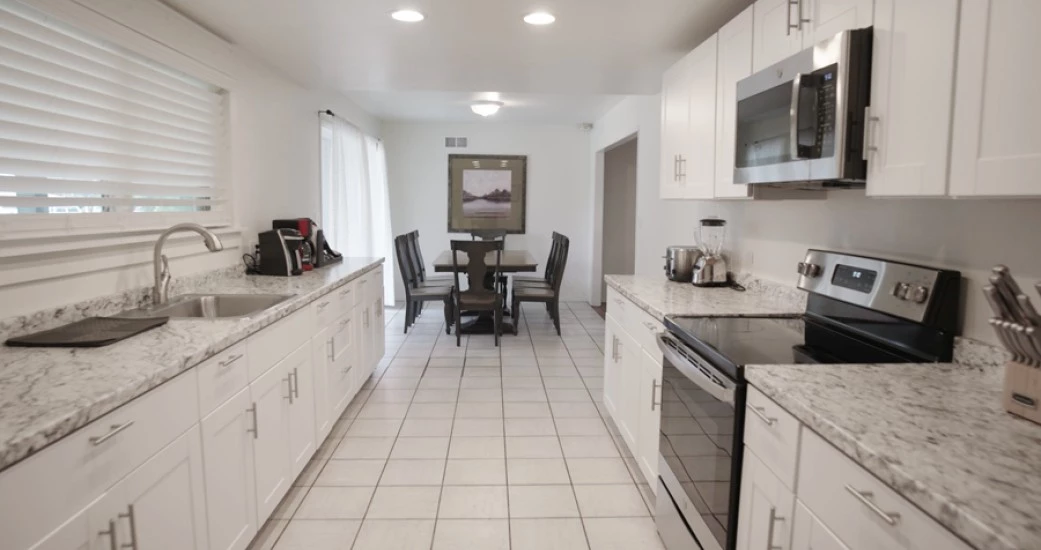 a kitchen with white cabinets and a table