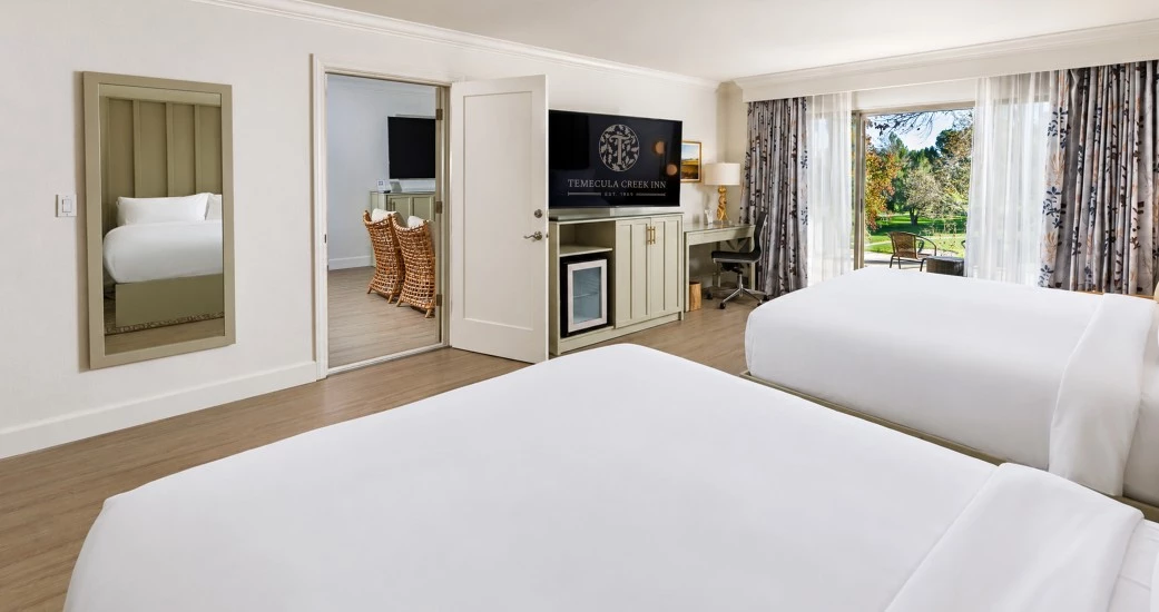 a room with two beds and a television