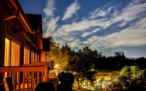 a house with a deck and trees in the back